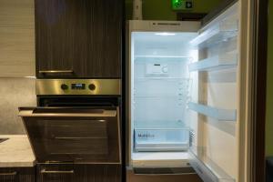 an empty refrigerator with its door open in a kitchen at Tsitsipas Apartment in Alexandroupoli