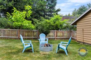 three chairs sitting around a fire pit in a yard at Charming Pet-Friendly Lake Retreat in Lake Geneva