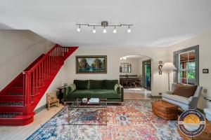 a living room with a green couch and a red staircase at Lake Geneva Escape 4BR Arcade Fire Pit and Deck in Lake Geneva