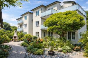 an apartment building with a garden in front of it at Villa Manatee mit Sauna & Fitness in Ostseebad Sellin