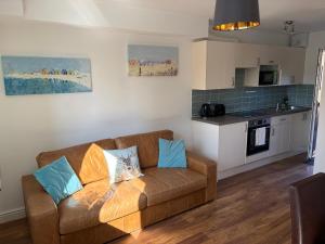 a living room with a couch and a kitchen at Smithaleigh Farm Rooms and Apartments in Plymouth