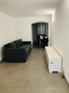 a living room with a black couch and a tile floor at Ile Rousse in LʼÎle-Rousse