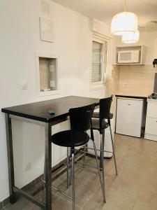 a kitchen with a black table and two chairs at Ile Rousse in LʼÎle-Rousse