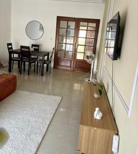 a living room with a television and a dining room table at Appartement Bissau in Dakar
