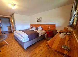 a bedroom with a bed and a desk with a chair at Gästehaus Holzer Kreuz - Gästezimmer Veilchen für 2 Personen inkl Landfrühstück in Fröhnd