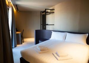 a bedroom with a bed with two towels on it at Ku Private Milano in Pero