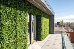 a green wall on the side of a building at Ku Private Milano in Pero