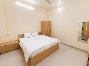 a bedroom with a bed and a mirror on the wall at Hotel Shreenath Heritage in Ujjain