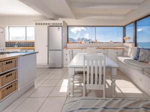 a kitchen with a table and a kitchen with a couch at Ocean View 147 in Struisbaai