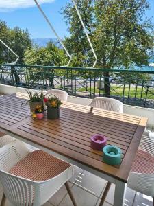 a wooden table on a balcony with plants on it at The cozy seaside apartment in Nafpaktos