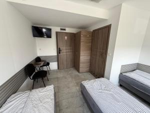 a bedroom with two beds and a desk and a table at Kwatery Smroków in Smroków