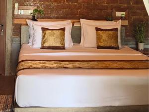 a bed with white sheets and pillows in a room at Lake View Cabana near Tangalle in Tangalle