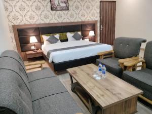 a hotel room with a bed and two chairs and a table at Hotel Vinayak International in Muzaffarpur
