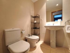 a white bathroom with a toilet and a sink at AC Apartaments Saüc Canillo in Canillo +26 photos