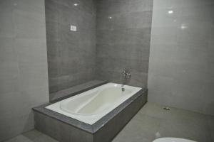 a bathroom with a bath tub and a toilet at Hotel Vinayak International in Muzaffarpur