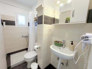 a small bathroom with a toilet and a sink at Irene Studios in Arillas
