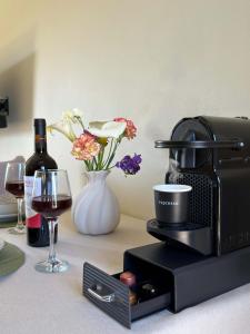 a counter with a coffee maker and a glass of wine at Irene Studios in Arillas