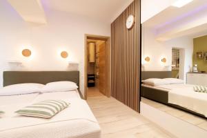 a bedroom with two beds and a hallway at Apartmani Enna in Mali Lošinj