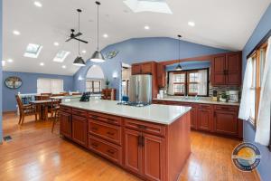 a large kitchen with wooden cabinets and a dining room at Exclusive Lake Como Escape with Bar and Pool Table in Lake Geneva