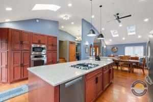 a kitchen with wooden cabinets and a stove top oven at Exclusive Lake Como Escape with Bar and Pool Table in Lake Geneva