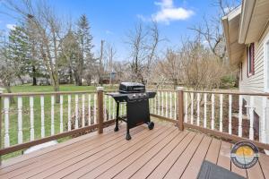 a grill on a wooden deck with a fence at Exclusive Lake Como Escape with Bar and Pool Table in Lake Geneva
