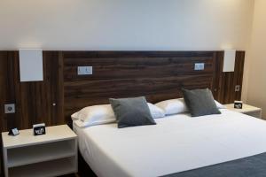 a bedroom with a large white bed with two night stands at Alda Ruta Castilla in Palencia