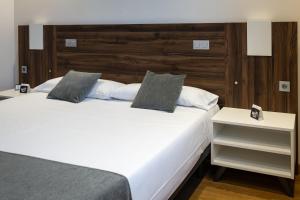 a bedroom with two beds with white sheets and pillows at Alda Ruta Castilla in Palencia