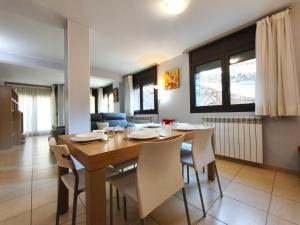 a dining room with a wooden table and chairs at AC Apartaments Saüc Canillo in Canillo