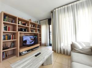 a living room with a tv and bookshelves at AC Apartaments Saüc Canillo in Canillo
