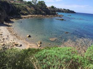 a beach with a rocky shore and the ocean at Villa Edo Cefalù in Cefalù