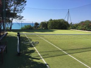 a tennis court with a net and the ocean at Villa Edo Cefalù in Cefalù +36 photos