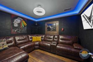 a living room with a brown leather couch at Event Lounge with Pool Table and Arcade in Lake Geneva