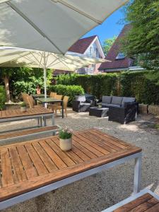 eine Terrasse mit Tisch, Stühlen und Sonnenschirm in der Unterkunft Ringhotel Appelbaum Gütersloh in Gütersloh