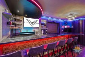 a bar with a bunch of stools in a room at Event Lounge with Pool Table and Arcade in Lake Geneva +29 photos