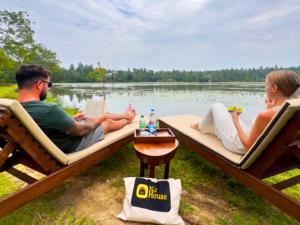 two people sitting in chairs on the side of a lake at Lake View Cabana near Tangalle in Tangalle