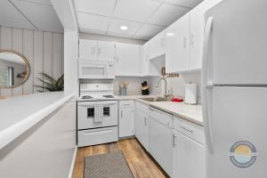 a white kitchen with a stove and a refrigerator at Lake Como Condo with Lake Views and Pool in Lake Geneva