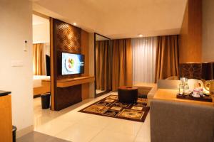 a hotel room with a television and a living room at Metland Seva Seminyak - Formerly Horison Ultima Seminyak in Seminyak