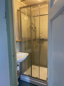 a bathroom with a glass shower and a sink at Gästis in Sollefteå