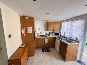 a small kitchen with wooden cabinets and a sink at Casa G in Bridlington