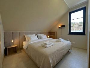 a bedroom with a large bed with towels on it at FORESTA in Redliny