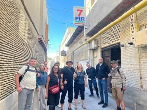 a group of people standing outside of a building at 7 Pir in Bukhara