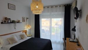 a bedroom with a bed and a large window at LOS NAREJOS Hotel in Los Alcázares