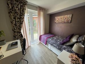 a small bedroom with a bed and a window at Chrysanthemum Drive stays in Shinfield