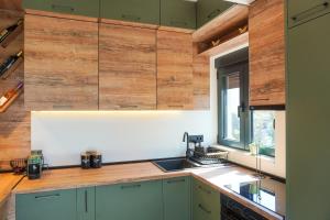 a kitchen with green cabinets and a sink and a window at Casa Oliva Tivat in Tivat