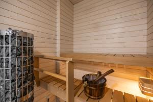 a cabin with a sauna with a bucket at Lumi Apartments in Rovaniemi