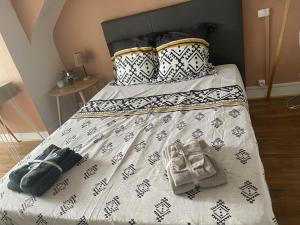 a bed with a black and white comforter and pillows at Croix rouge in Châtellerault