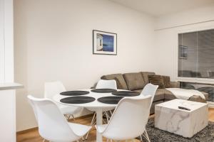 a living room with a table and white chairs at Lumi Apartments in Rovaniemi