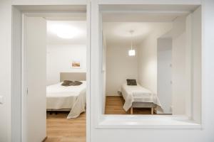 a white room with a bed and a window at Lumi Apartments in Rovaniemi