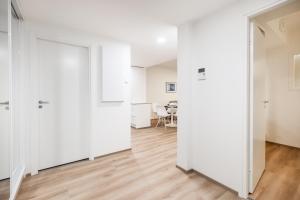 an open door in a white room with a table at Lumi Apartments in Rovaniemi +7 photos