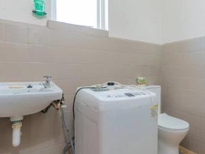 a small bathroom with a sink and a toilet at Kusweg Oos 1 in Struisbaai +4 photos